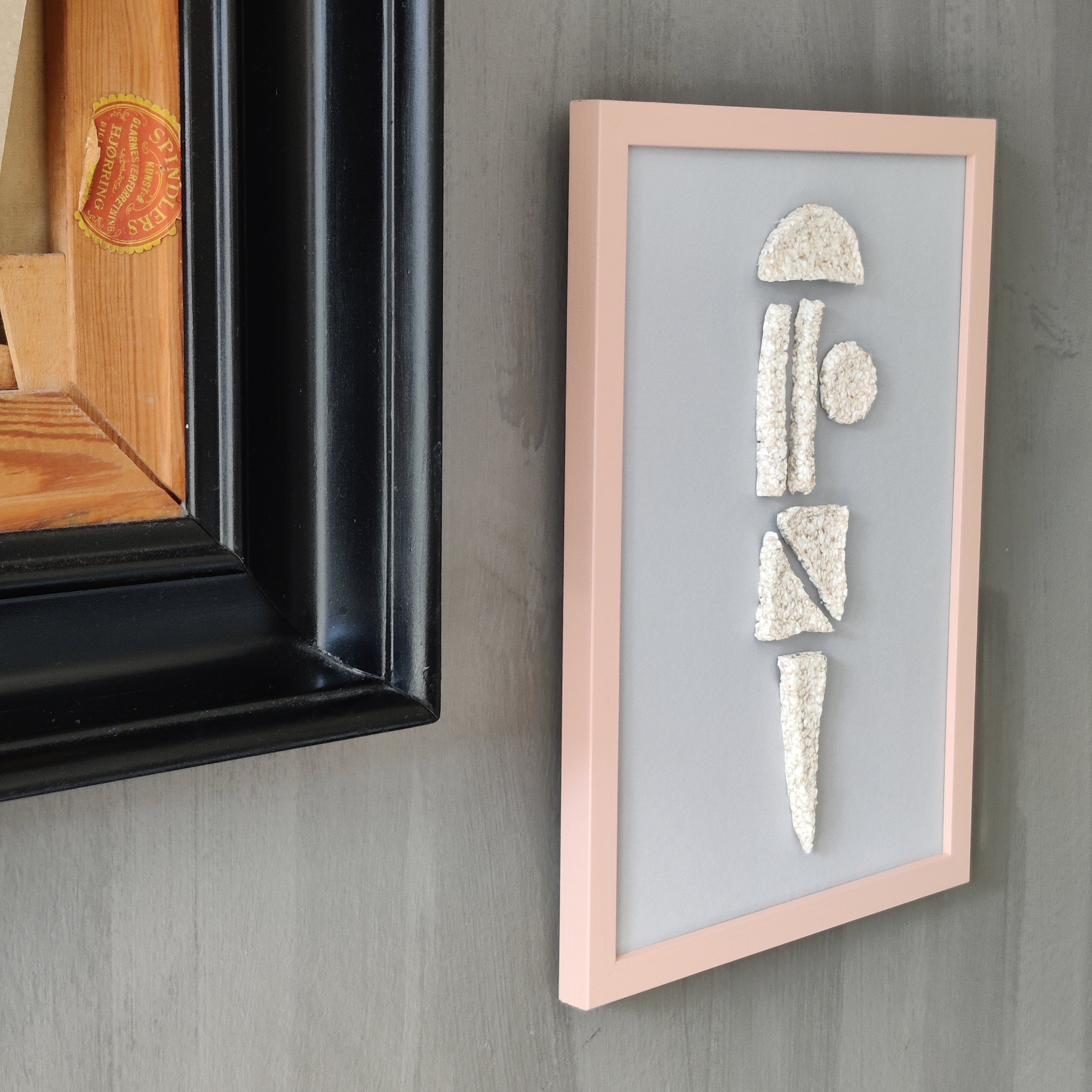 Framed artwork with geometric shapes on a gray wall