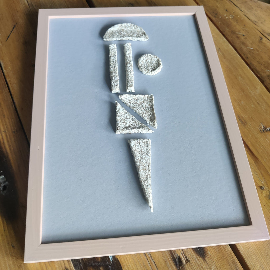 Framed artwork with abstract white shapes on a light blue background