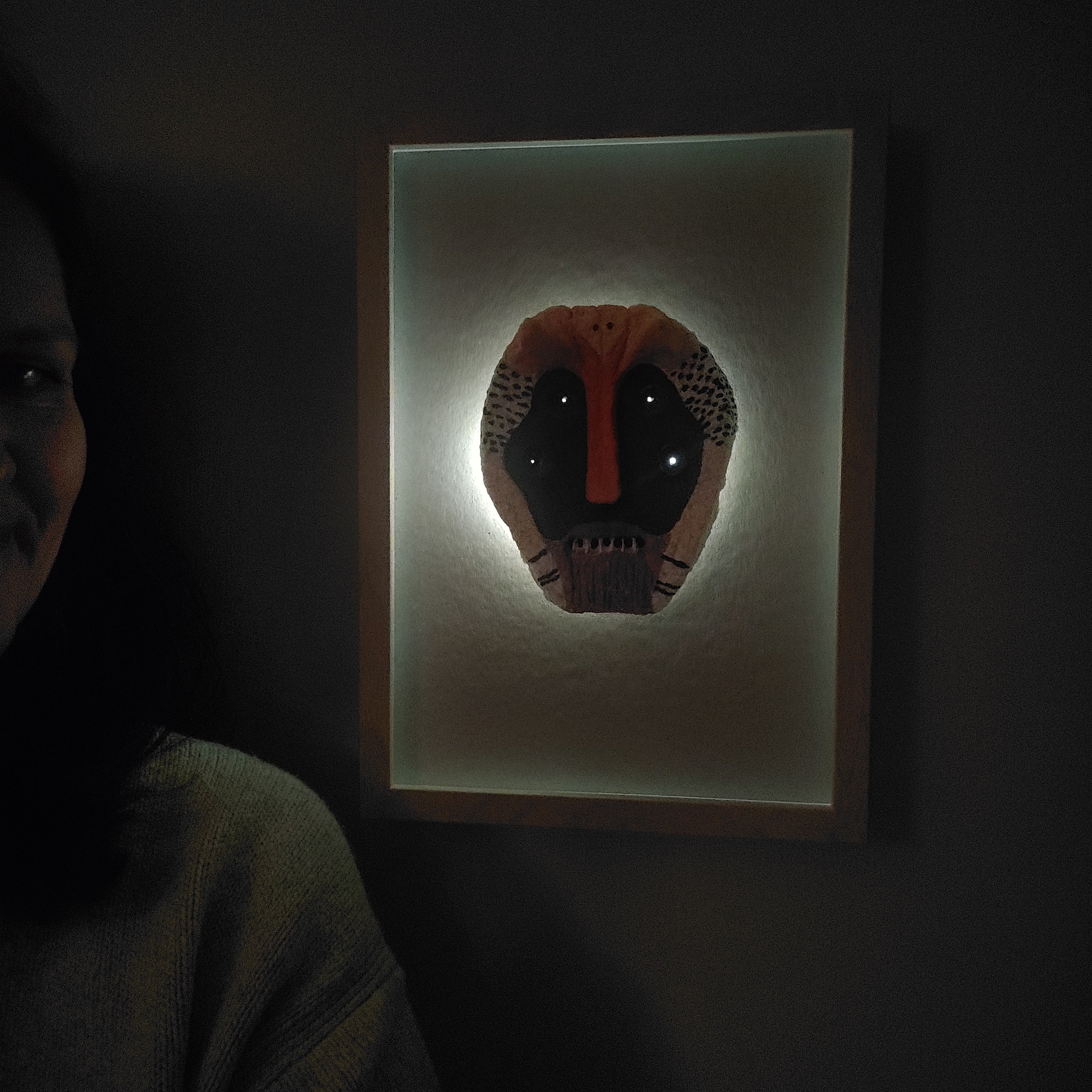 Lisa Ketty standing next to her Primal Pulp Mask paper pulp wall art