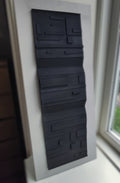 Black textured panel on a white wall next to window