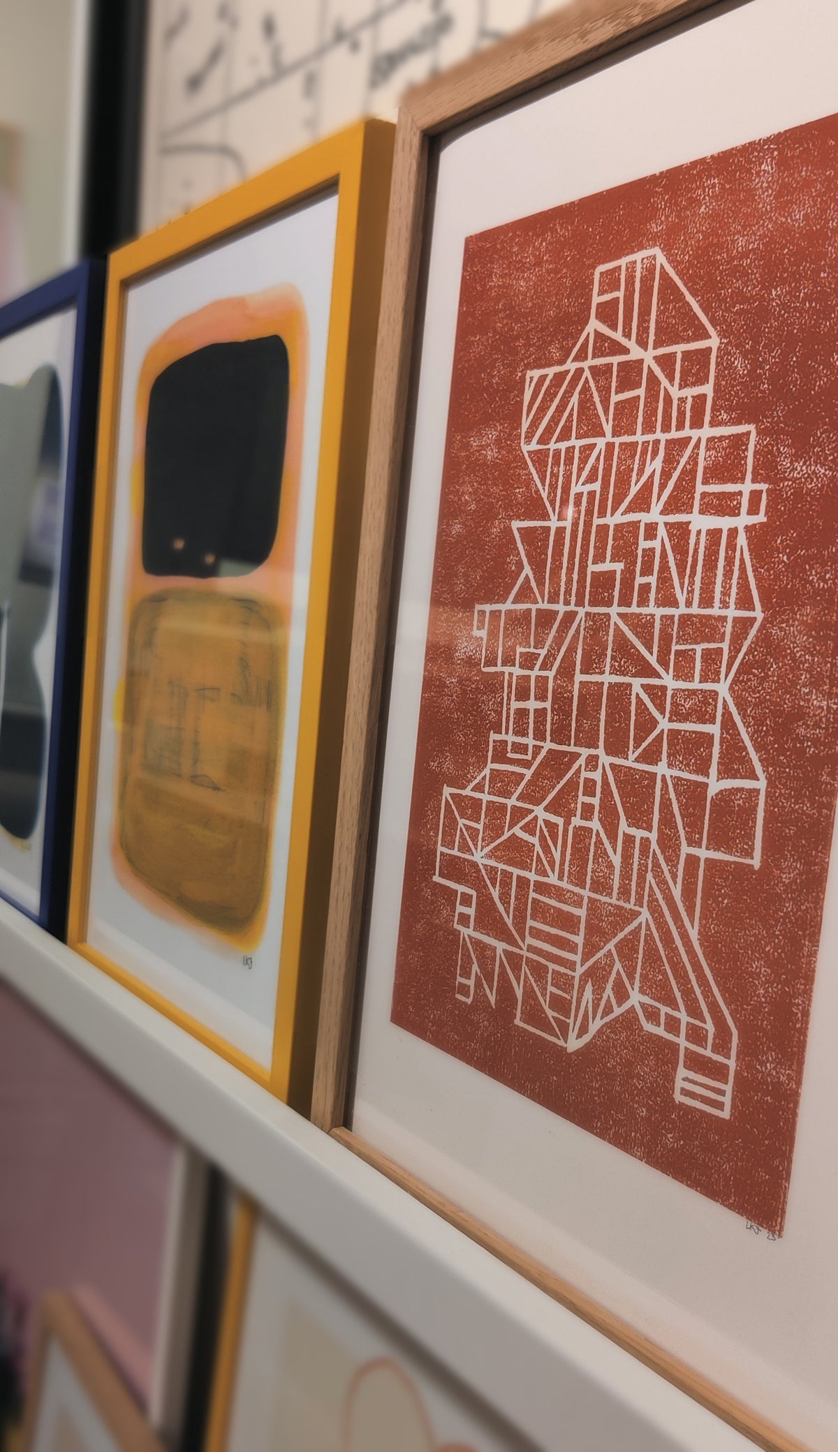 Sættekasse Poster by Lisa Ketty framed on a picture ledge next to other prints